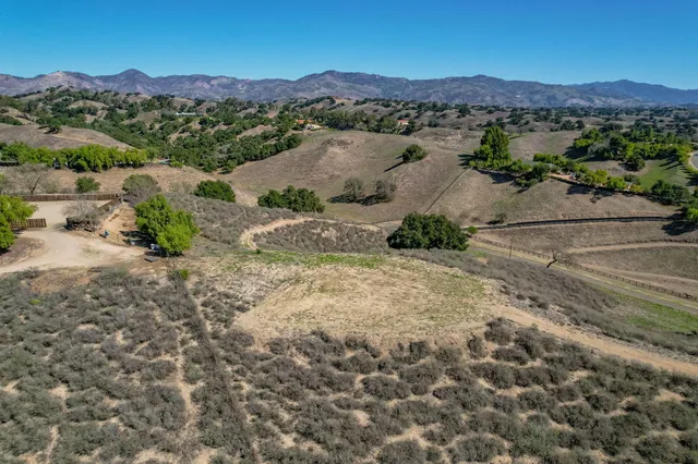 an aerial view of mountain with residential house and green space