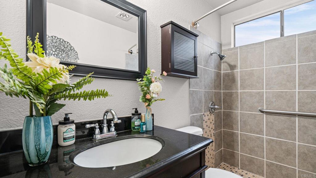 12741 Laurel Street, Unit 34 Lakeside, CA 92040 - Photo 12 of 30 a bathroom with a granite countertop sink a mirror and shower