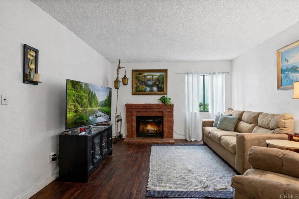 12741 Laurel Street, Unit 34 Lakeside, CA 92040 - Photo 2 of 30 a living room with furniture a flat screen tv and a fireplace