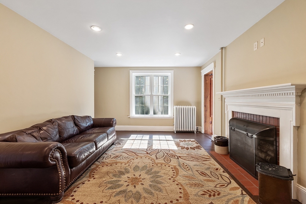 64 Central Street Gardner, MA 01440 - Photo 21 of 42 a living room with a couch a fireplace and a window