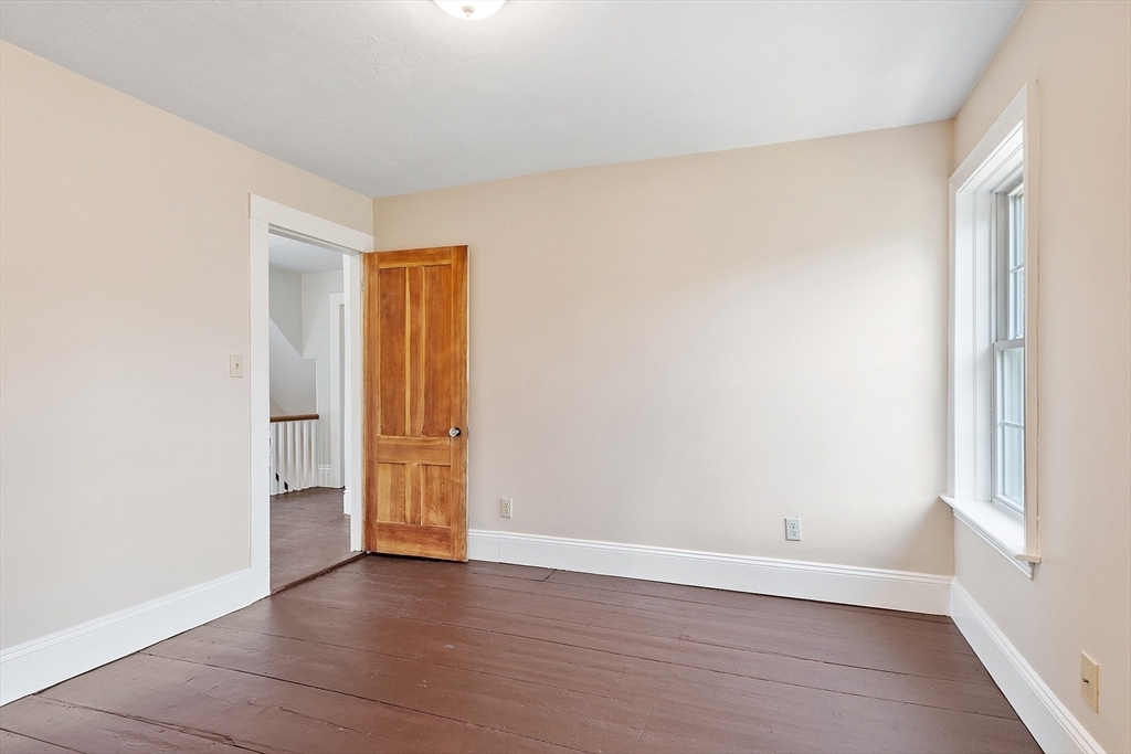 64 Central Street Gardner, MA 01440 - Photo 31 of 42 an empty room with wooden floor and window
