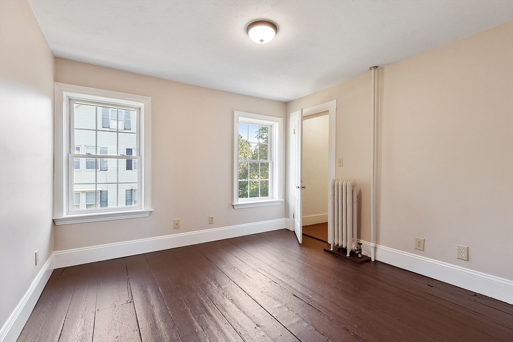 64 Central Street Gardner, MA 01440 - Photo 32 of 42 an empty room with wooden floor and windows