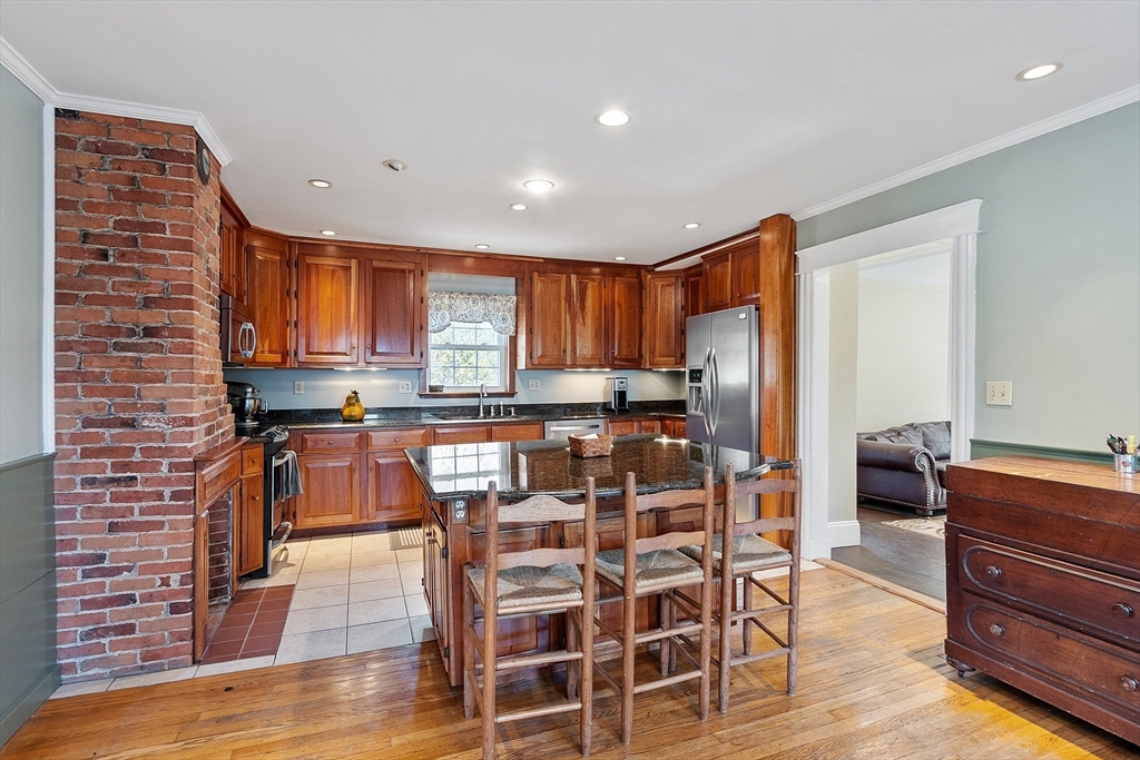 64 Central Street Gardner, MA 01440 - Photo 8 of 42 a kitchen with stainless steel appliances kitchen island granite countertop a refrigerator and wooden cabinets
