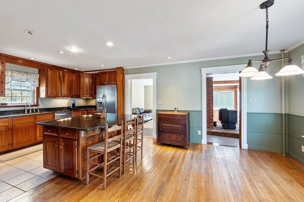 64 Central Street Gardner, MA 01440 - Photo 9 of 42 a kitchen with stainless steel appliances granite countertop a refrigerator a sink dishwasher a stove and a dining table with wooden floor