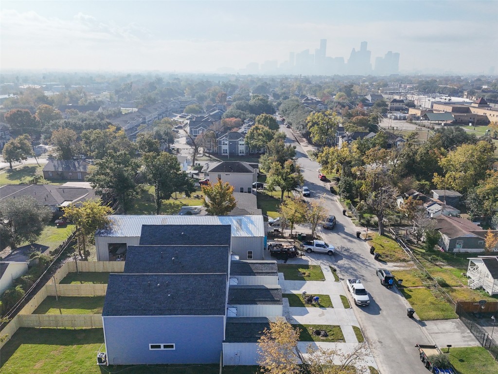 3422 Elser Street Houston, TX 77009 - Photo 18 of 26 This aerial photo shows a residential neighborhood with modern homes, tree-lined streets, and a clear view of the city skyline in the distance. The area appears peaceful and well-maintained, offering a suburban feel with urban accessibility.