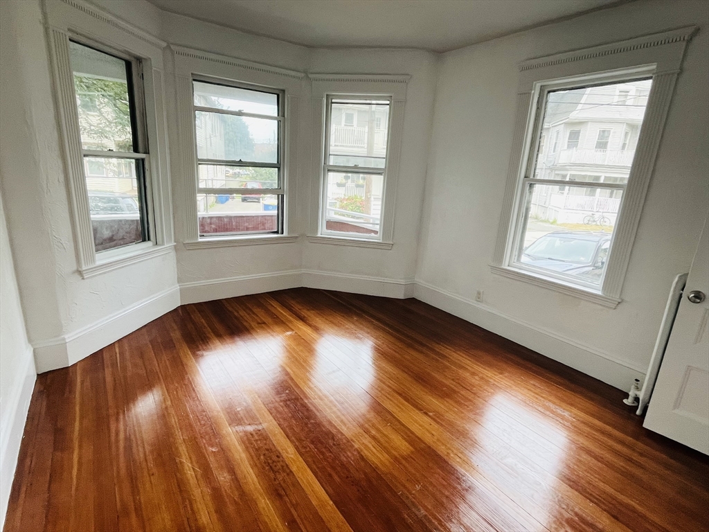 19 Beach Road, Unit 1 Winthrop, MA 02152 - Photo 5 of 9 a view of empty room with wooden floor and fan