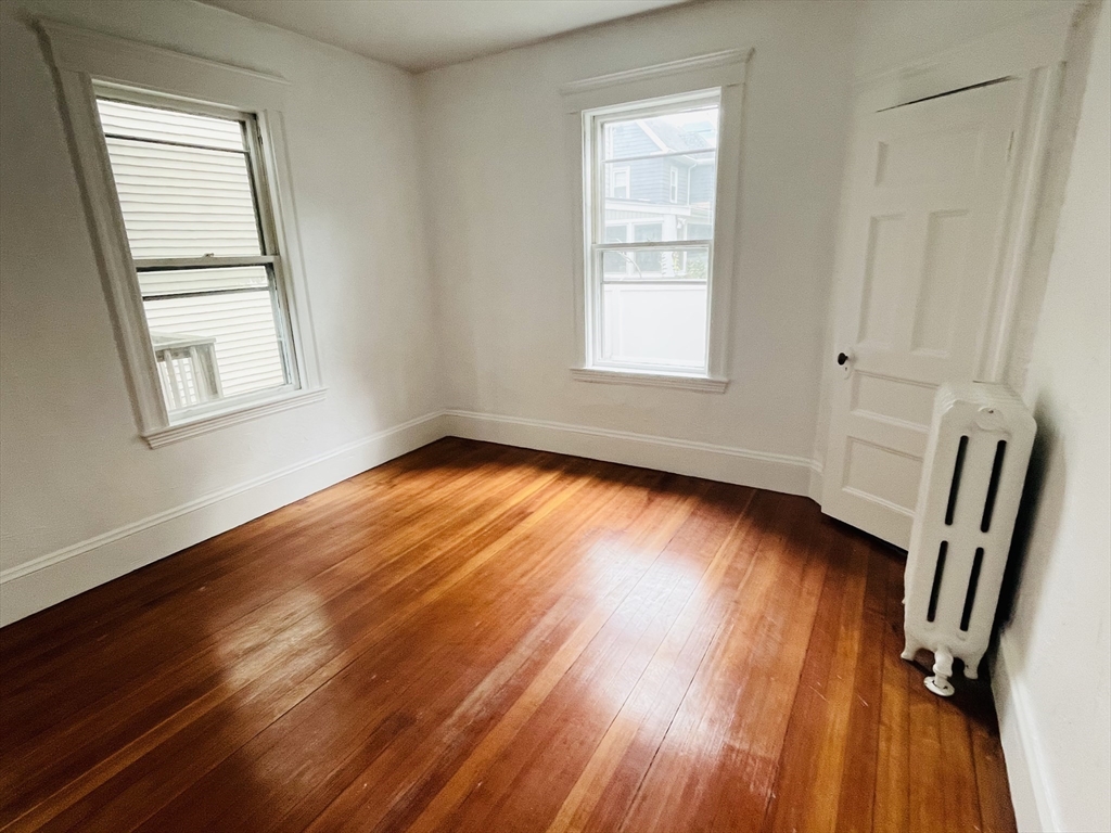 19 Beach Road, Unit 1 Winthrop, MA 02152 - Photo 7 of 9 a view of an empty room with wooden floor and a window