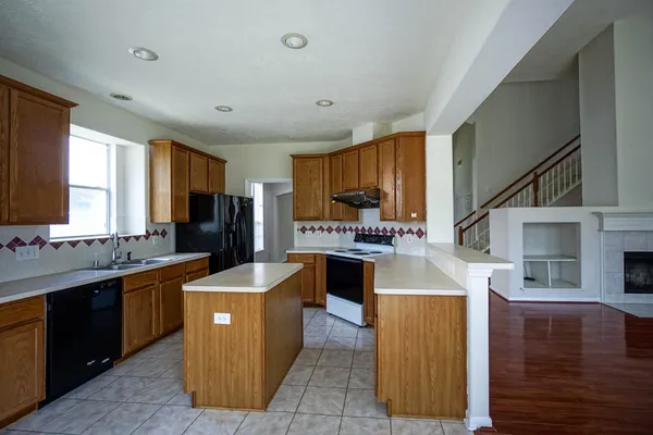 a large kitchen with kitchen island a sink counter top space a stove and cabinets