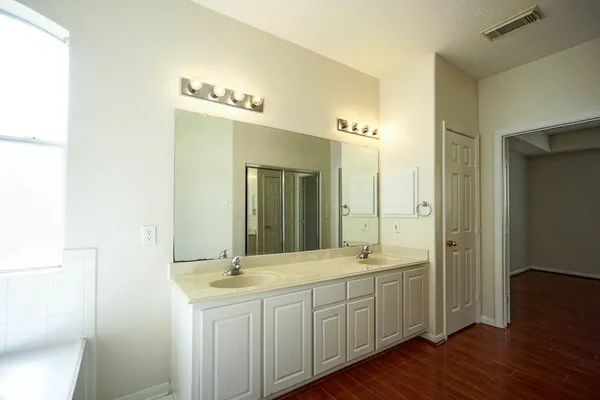 a bathroom with a double vanity sink and a mirror
