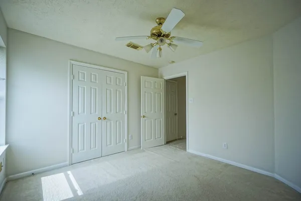 an empty room with a chandelier fan