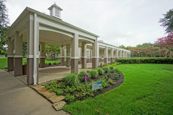 a view of a house with brick walls and a yard with potted plants