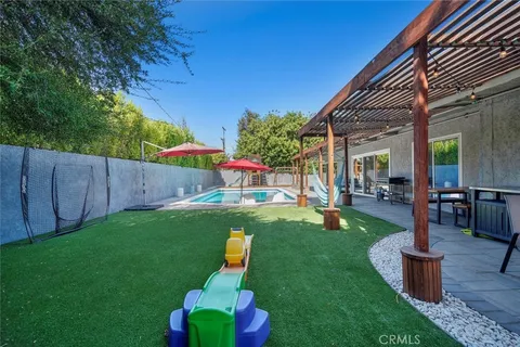 a view of backyard with seating space and slide
