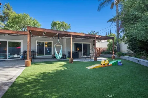 a view of a house with a backyard patio and swimming pool