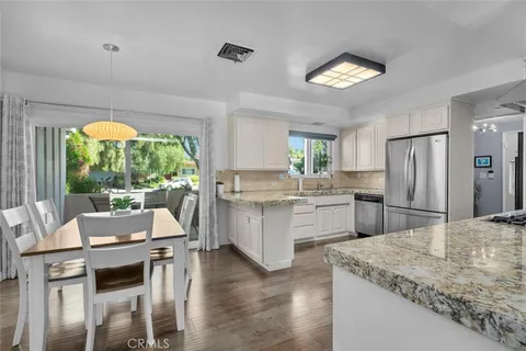a kitchen with a table chairs refrigerator and cabinets