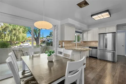 a dining room with furniture a kitchen view and a large window