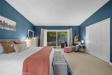 a bedroom with bed and large windows