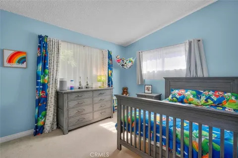 a bedroom with furniture a baby crib toys and a window