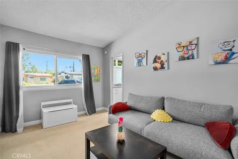 a living room with furniture and a kitchen view