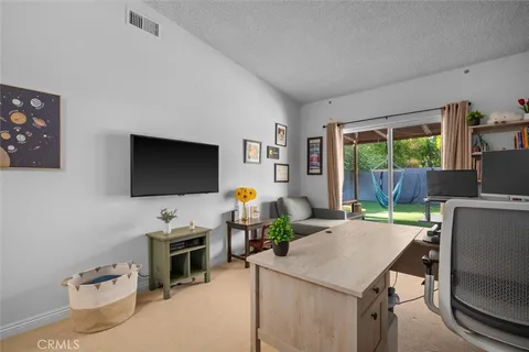 a living room with furniture a flat screen tv and a floor to ceiling window