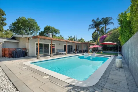 a view of a house with backyard swimming pool and sitting area