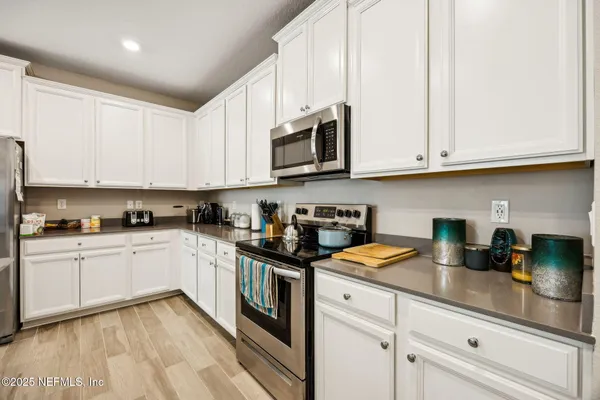 a kitchen with stainless steel appliances granite countertop a sink a stove and cabinets