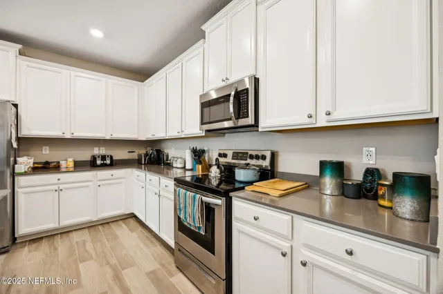 a kitchen with stainless steel appliances granite countertop a sink a stove and cabinets