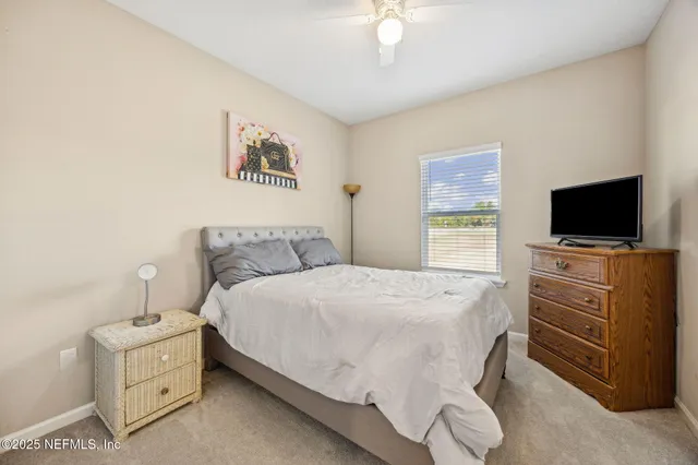 a spacious bedroom with a bed and a flat screen tv