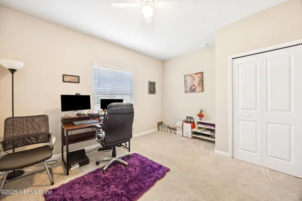 a view of a workspace with furniture and a window