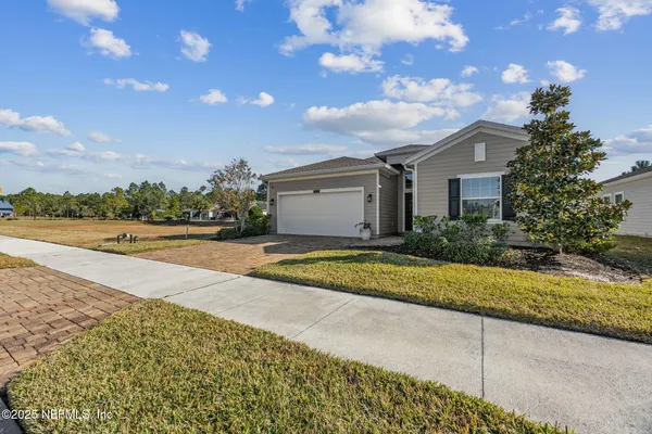 a view of a house with a yard and potted plants