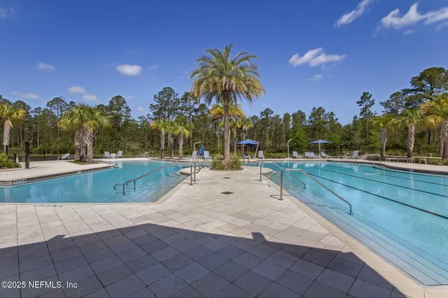 a view of wooden deck and lake with trees in the background