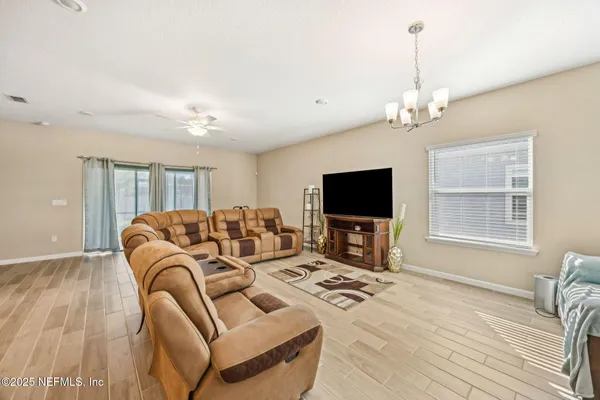 a living room with furniture a flat screen tv and a large window