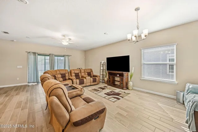 a living room with furniture a flat screen tv and a large window