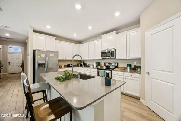 a kitchen with refrigerator cabinets dining table and chairs
