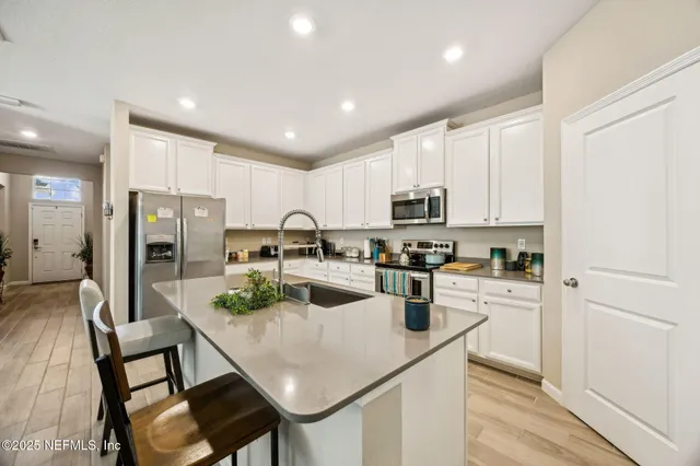 a kitchen with refrigerator cabinets dining table and chairs