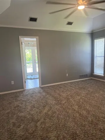 en empty room with windows and fan