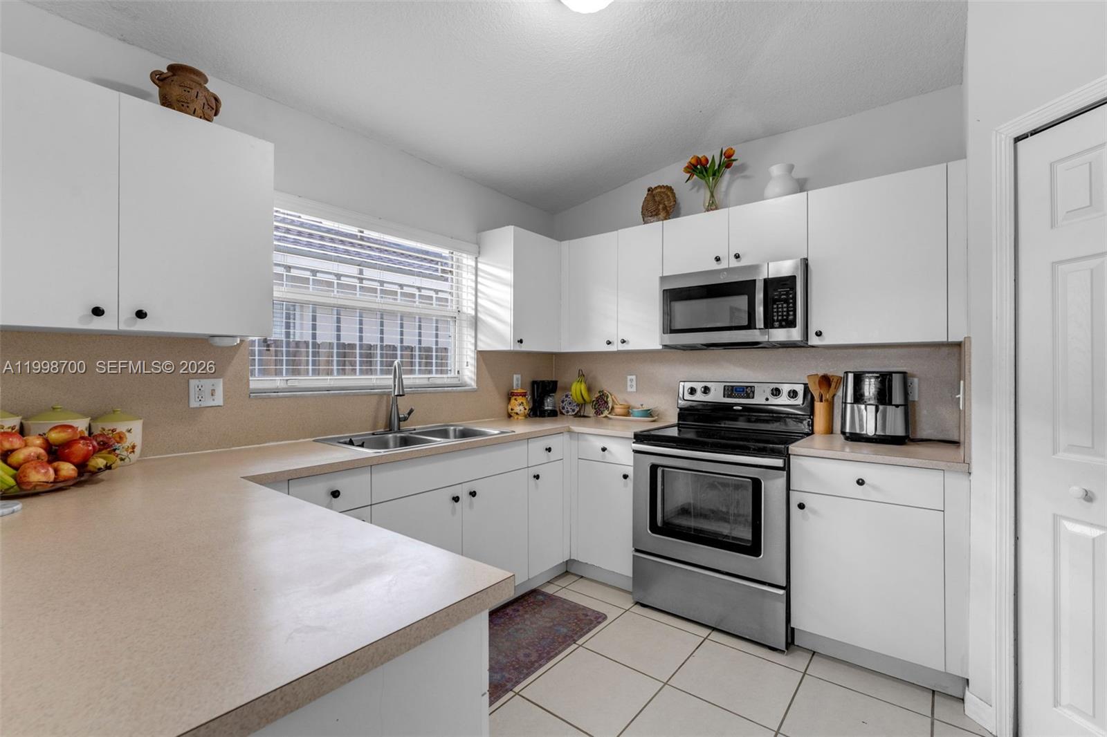 13471 Southwest 278th Terrace Homestead, FL 33032 - Photo 27 of 32 a kitchen with a sink a stove and cabinets