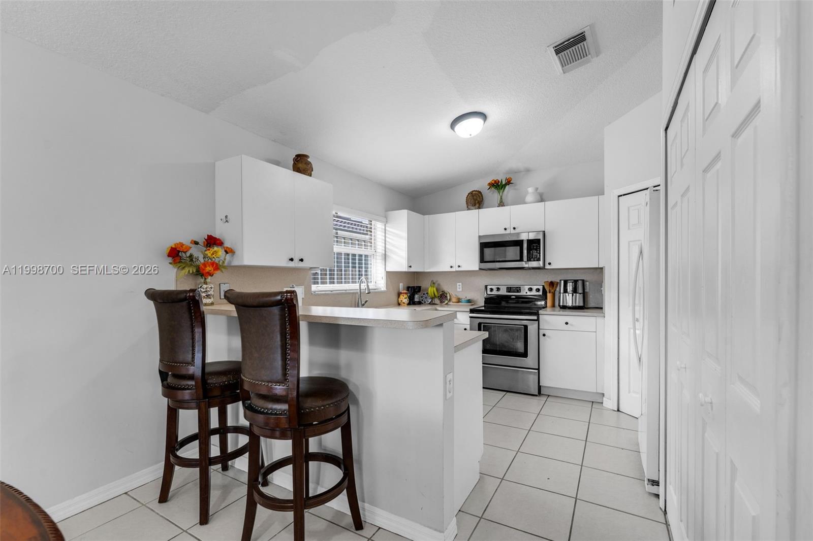 13471 Southwest 278th Terrace Homestead, FL 33032 - Photo 28 of 32 a kitchen with stainless steel appliances granite countertop a stove top oven a sink dishwasher and a refrigerator