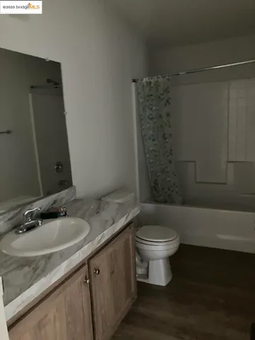a bathroom with a granite countertop sink a toilet a mirror and shower