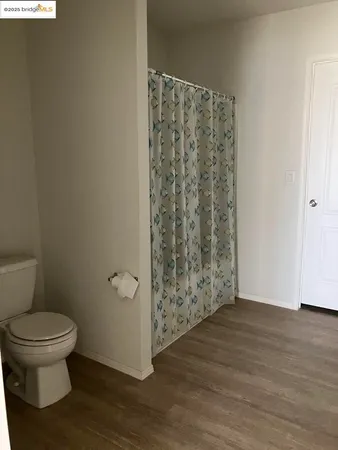 a bathroom with a toilet and a shower curtain