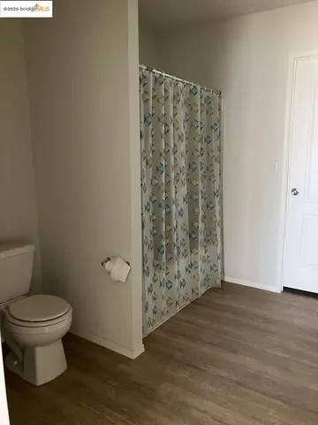 a bathroom with a toilet and a shower curtain
