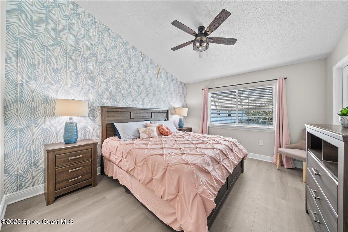 2730 Cutlass Point Lane, Unit 101 Merritt Island, FL 32953 - Photo 12 of 31 a bedroom with a bed a chandelier and a window