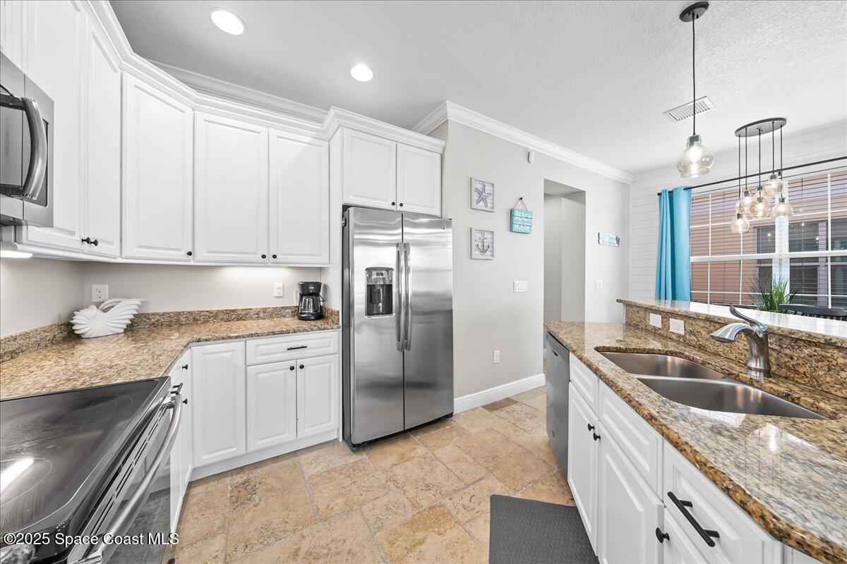 2730 Cutlass Point Lane, Unit 101 Merritt Island, FL 32953 - Photo 7 of 31 a kitchen with granite countertop a sink stove and refrigerator
