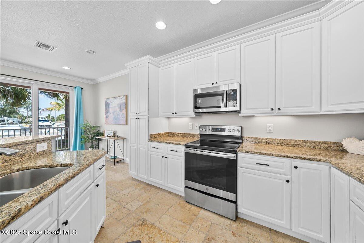2730 Cutlass Point Lane, Unit 101 Merritt Island, FL 32953 - Photo 8 of 31 a kitchen with stainless steel appliances granite countertop a sink stove and refrigerator