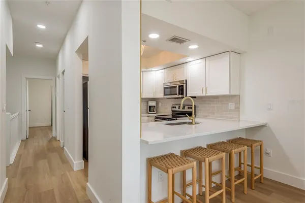 a kitchen with granite countertop a refrigerator and microwave