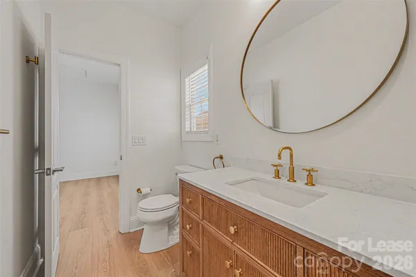 a bathroom with a sink a toilet and a mirror