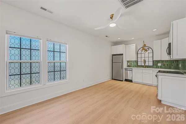 a open kitchen with white cabinets and stainless steel appliances