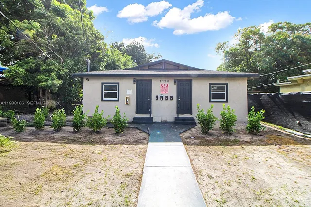 a front view of house with yard and trees around