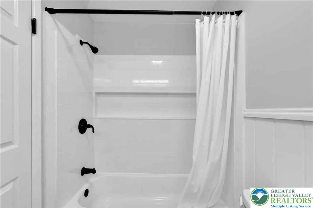 2011 Greenwood Road Allentown, PA 18103 - Photo 32 of 52 A pristine white tile surround with matte black fixtures frames this well-appointed shower and tub.