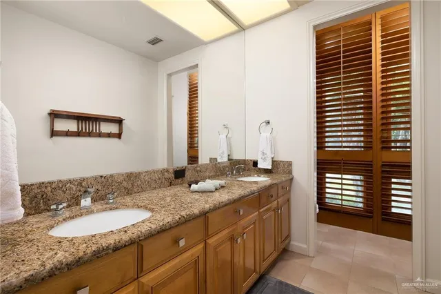 a bathroom with a granite countertop sink and a mirror