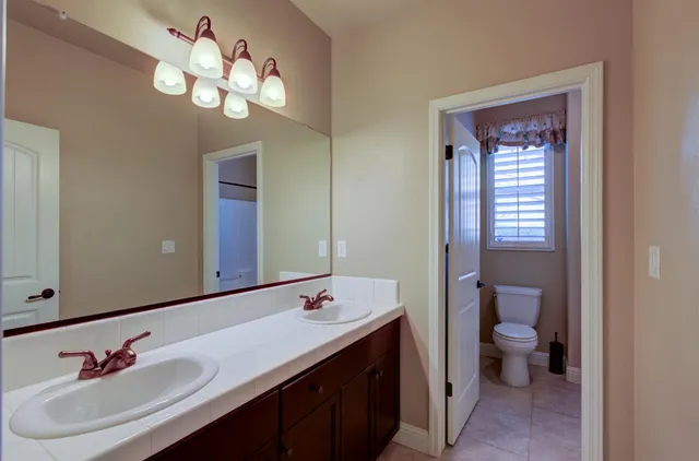 a bathroom with a double vanity sink and a toilet